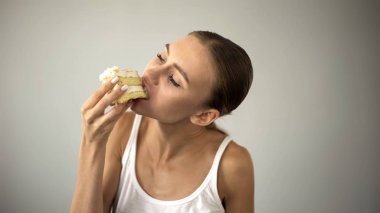 İnce kız diyet ve aç, öz-disiplin eksikliği hevesle, pasta yemeye