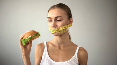 Anoreksik kız ağız bandı ile bağları, burger yemeye günaha ile savaşır