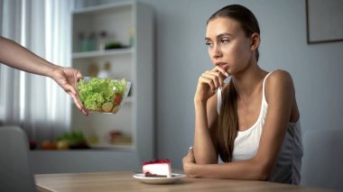 İnce kız pasta veya salata, kalori vs sağlıklı beslenme yemeye karar üzerinde düşünme