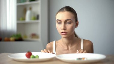 Kız sebze ve hap, sağlıklı beslenme vs ağırlık kaybı ilaçlar arasında seçim yapma