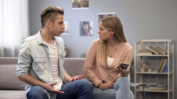 Девушка подозревает парня в измене, держит телефон с корреспонденцией, ревность
