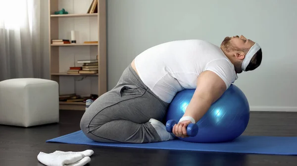 有目的超重男性举重哑铃躺在健身球 肌肉泵 — 图库照片