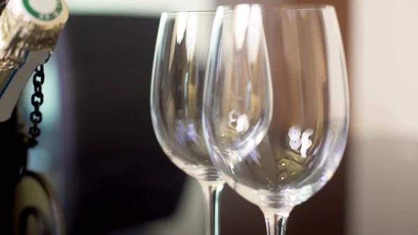 Δύο Κενές Wineglasses Και Μπουκάλι Σαμπάνιας Στέκεται Στο Τραπέζι Γιορτή — Φωτογραφία Αρχείου