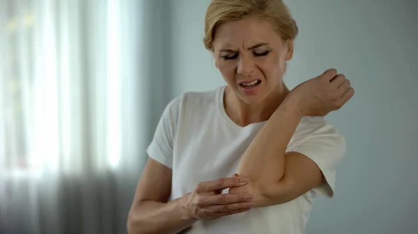 Blond Woman Suffering Elbow Pain Holding Her Aching Arm Injury — Stock Photo, Image