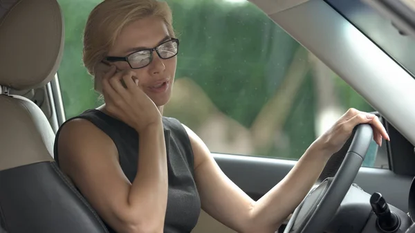 ニュース 友人とのおしゃべり 車で携帯電話で話している公式ドレスの女性 — ストック写真