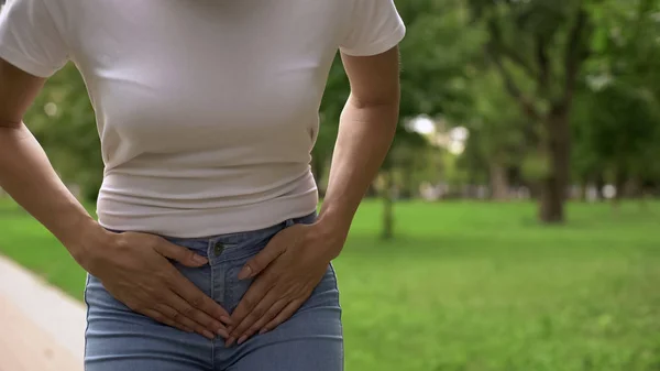 女性の下腹部痛 公園を歩いて 膀胱炎の症状を感じ — ストック写真