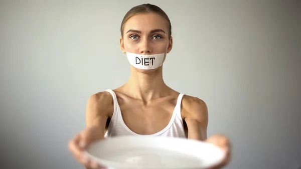 Slim Girl Taped Mouth Showing Empty Plate Severe Diet Self — Stock Photo, Image