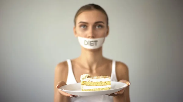 瘦小的女孩用胶带嘴拿着蛋糕 拒绝吃甜 低碳水化合物饮食 — 图库照片