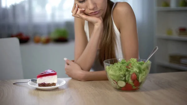 スリムな女性がケーキとサラダ 健康的な食事対高カロリー食品を選択します — ストック写真