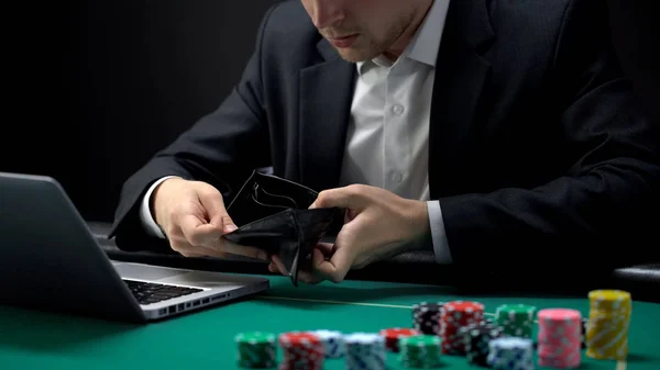 Nervous online gambler opening empty wallet, betting addiction, bankruptcy