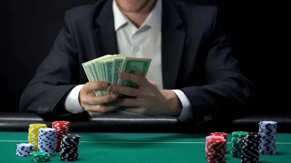 幸运赌场赢家持有美元钞票 筹码在桌子周围 游戏奖 — 图库照片