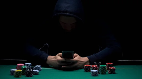 Anonymous male playing online game on smartphone app, illegal business, addict