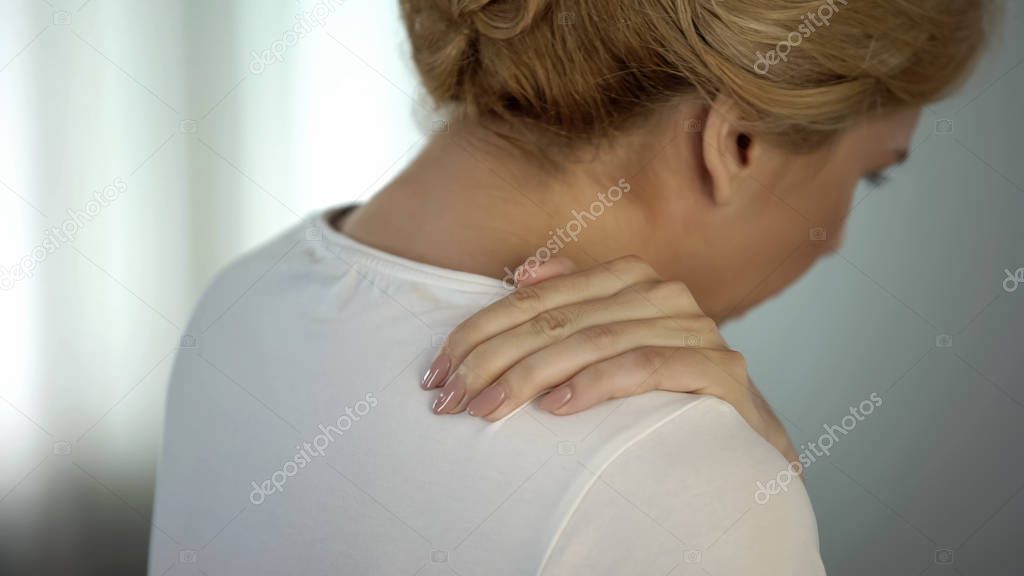 Blond female feeling terrible shoulder pain, nerve inflammation, therapy