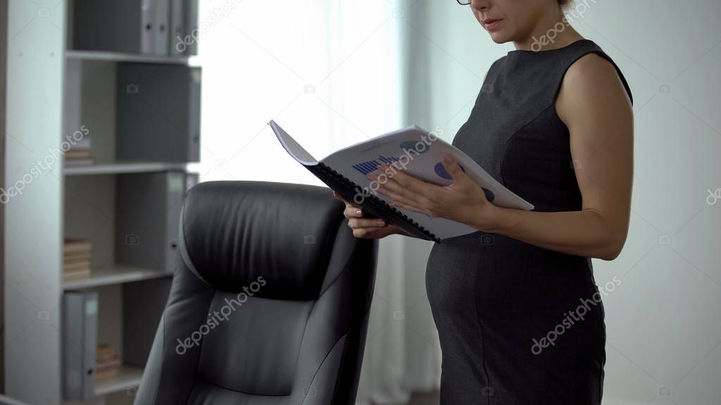 Pregnant business lady reading report in office, feeling back pain, muscle spasm