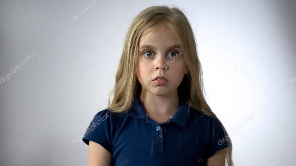 Scared little girl looking at camera with fear, children rights protection