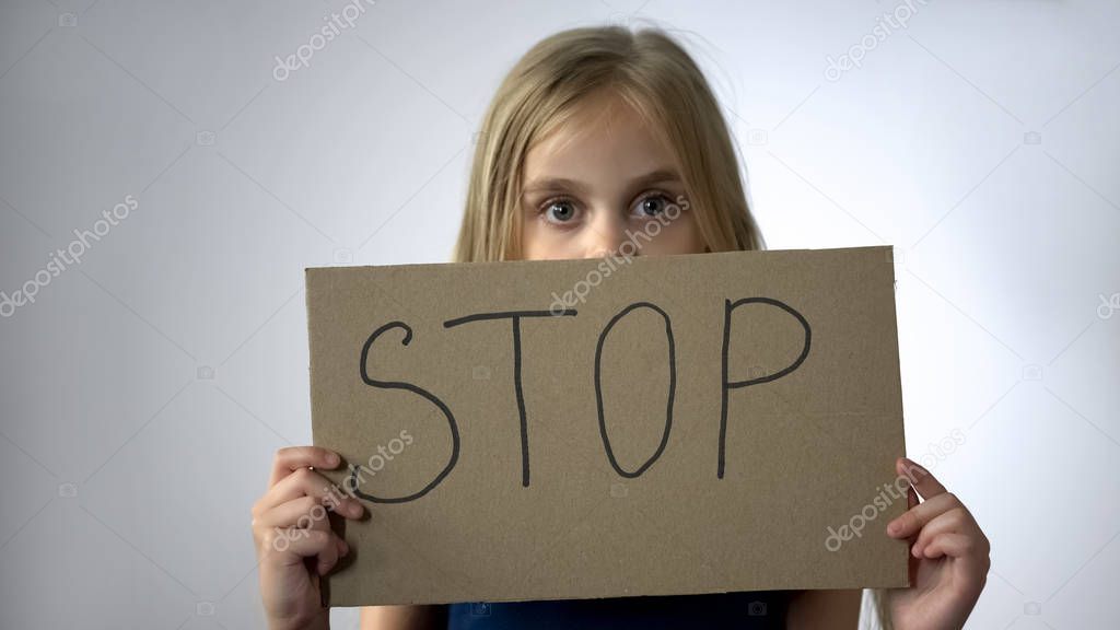 Girl shows stop sign, social protection of children domestic violence prevention