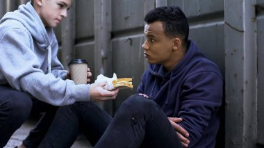 Teenage sharing lunch with afro-american friend, support in hard situation clipart