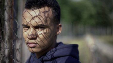 Metal çit tarafından hayat zorluklar kavram duran zavallı Afro-Amerikan Genç