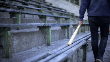Beyzbol sopası, gençlik çetesinin, vandalizm ile Stadyum Tribün üzerinde yürüyen genç adam