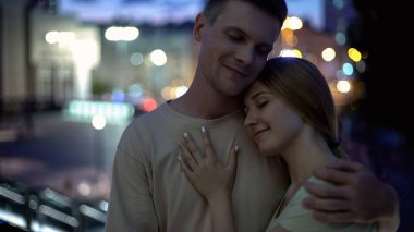 Güzel çift şefkatle gece şehir arka planı, sarılma romantik tarih