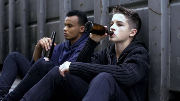 青少年男孩喝啤酒坐在路上 坏公司的影响 — 图库照片