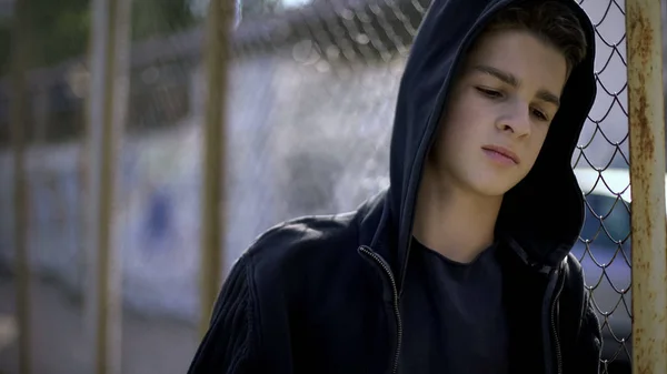 寄宿学校 閉じ込めの孤児 フェンスに寄りかかってのパーカー少年 — ストック写真