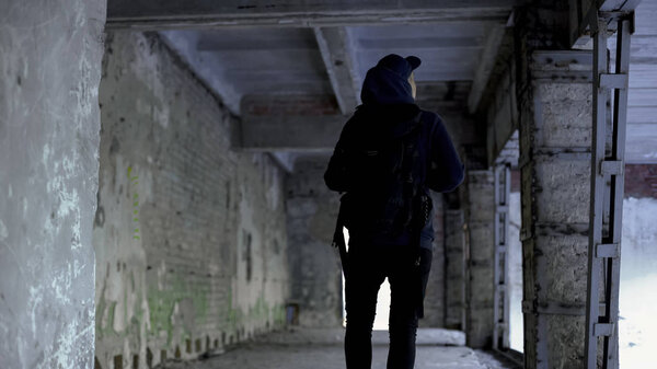 Teenage boy walking in abandoned house, dangerous place, risk of kidnapping
