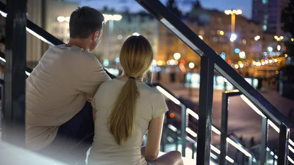 Paar Sitzt Auf Der Treppe Umarmt Sich Sieht Beleuchtete Abendstadt — Stockfoto