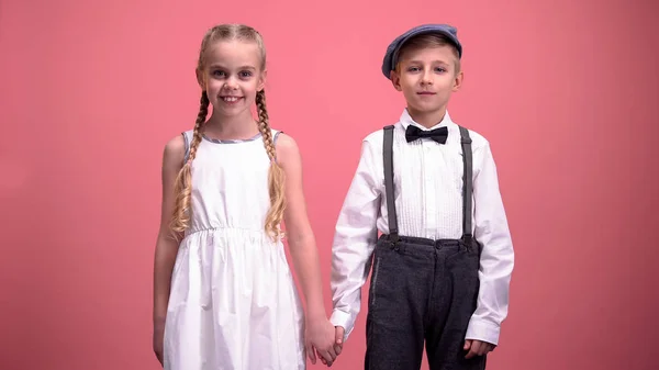 Sorrindo Menino Menina Olhando Para Câmera Mãos Dadas Fundo Rosa — Fotografia de Stock