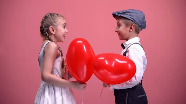 Paar Schattige Kinderen Uitwisselen Rode Hartvormige Ballonnen Valentijnsdag Cadeau — Stockfoto