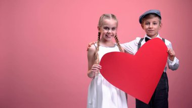 Büyük kırmızı kalp sarılma ve gülümseyen, Romantik Sevgililer günü ile genç çift