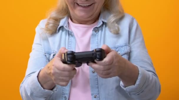 Возбужденная Бабушка Играет Видеоигры Джойстиком Ярком Фоне Досуг Весело — стоковое видео