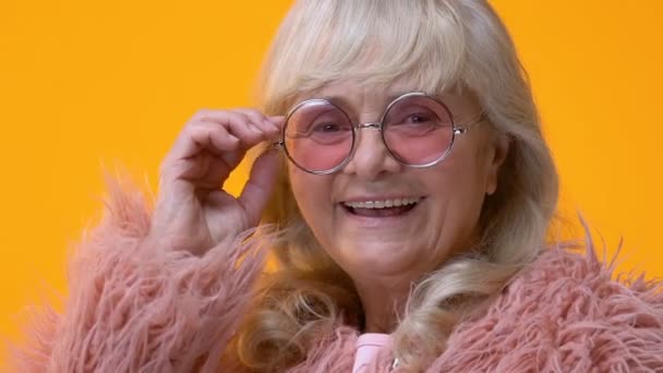 Mulher Sênior Feliz Óculos Elegantes Piscando Fundo Brilhante Flerte — Vídeo de Stock