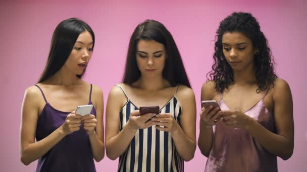 Meninas Com Smartphones Olhando Mensagem Texto Amigo Feminino Fundo Rosa — Vídeo de Stock