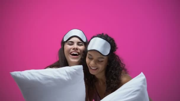 Dua Wanita Dengan Piyama Dan Masker Mata Memegang Bantal Memeluk — Stok Video