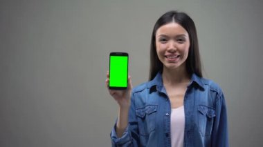 Çevrimiçi bankacılık, alışveriş smartphone ile yeşil ekran, gösterilen mutlu Asyalı kadın