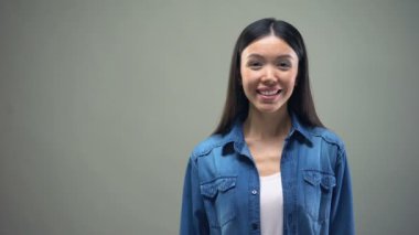 Asyalı kadın holding kredi kartı elinde nakit Hizmetleri, gri arka plan geri