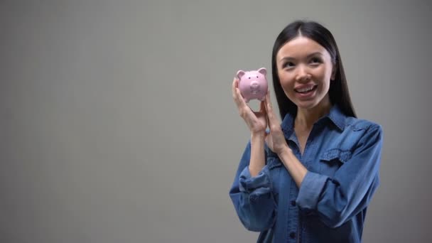Sonriente Chica Asiática Sacudiendo Alcancía Escuchando Zumbido Monedas Depósitos — Vídeos de Stock