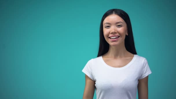 Wesoły Asian Kobieta Pokazuje Znak Białym Tle Niebieskim Tle Szablon — Wideo stockowe