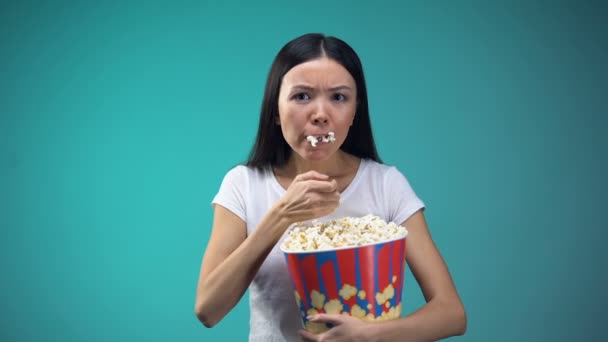 大きな紙コップからポップコーンを食べて映画女性に焦点を当てた不健康な食事 — ストック動画