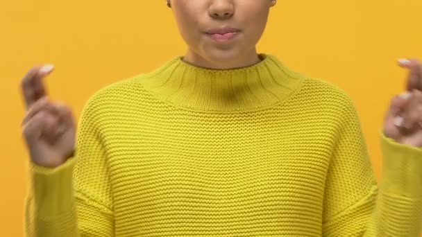黄色いセーターの指を交差 期待の女子大学生 — ストック動画