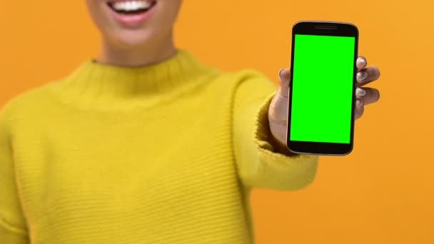 Улыбающаяся Юная Леди Желтом Свитере Показывает Смартфон Зеленым Экраном Приложение — стоковое видео