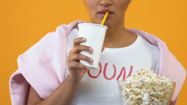 紙コップから飲み物を飲むとポップコーンを持って興奮している女の子ボウル 映画館 — ストック動画