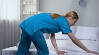 Temiz çarşaf yaşlı kadın hasta Tıp Merkezi için hazırlanıyor hemşire