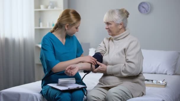 Cardiólogo Triste Escribiendo Diagnóstico Anciana Después Medición Presión Arterial — Vídeos de Stock