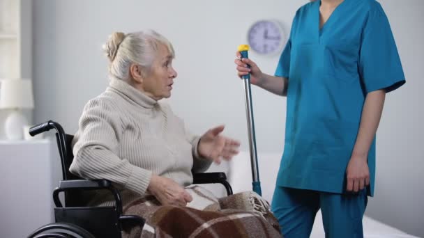 说话的老太太在轮椅上八卦与医院看门人 — 图库视频影像