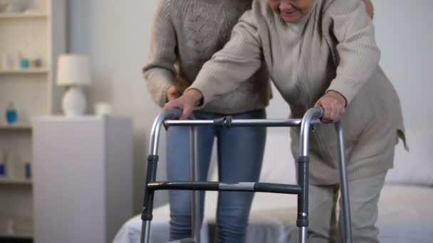 志愿者帮助老年妇女使用步行架 创伤后康复 — 图库视频影像
