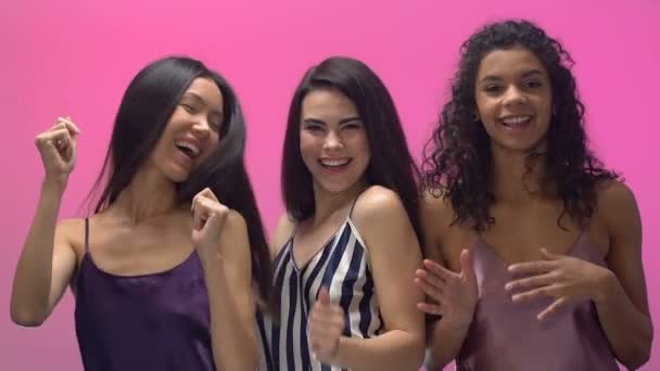 パジャマ ダンスし笑い ピンクの背景に分離された多民族の女性 — ストック動画