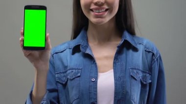 Genç Asyalı Bayan Smartphone yeşil ekran, uygulama geliştirme ile gösterilen