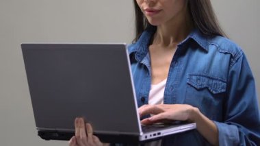 Genç Asyalı öğrenci dizüstü bilgisayar, iş onay e-postası hakkında heyecanlı yazarak